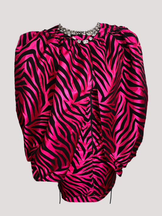 This show stopper dress is crafted in a fuchsia soft sheen taffeta. There are black velvet tiger stripes patterned all over. The dress can be worn long or detach the flared skirt bottom to wear the dress as a mini. There is one center front zipper and darts both in the front and back of the dress for a more fitted look. The dress features long sleeves and a high neckline. There is a  drawstring funneled through the bottom hem of the flared skirt for adjustability. 