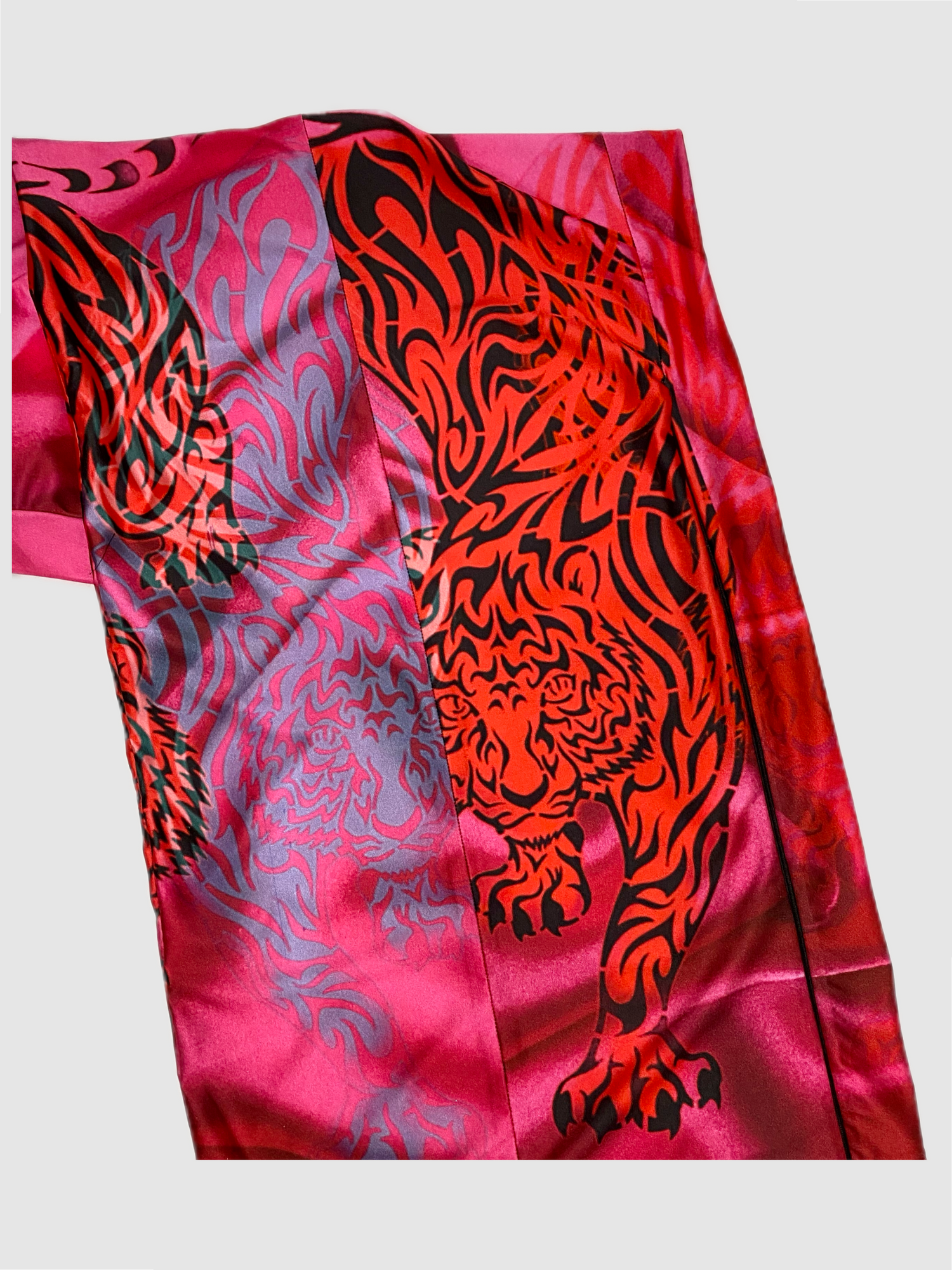 Image shows the back of the skirt. Each pattern is unique. The print shows a range in hues from light pink to fuchsia. The tigers appear in a trio formation. The skirt has one side slip with zipper, so the slit can be worn open or closed.