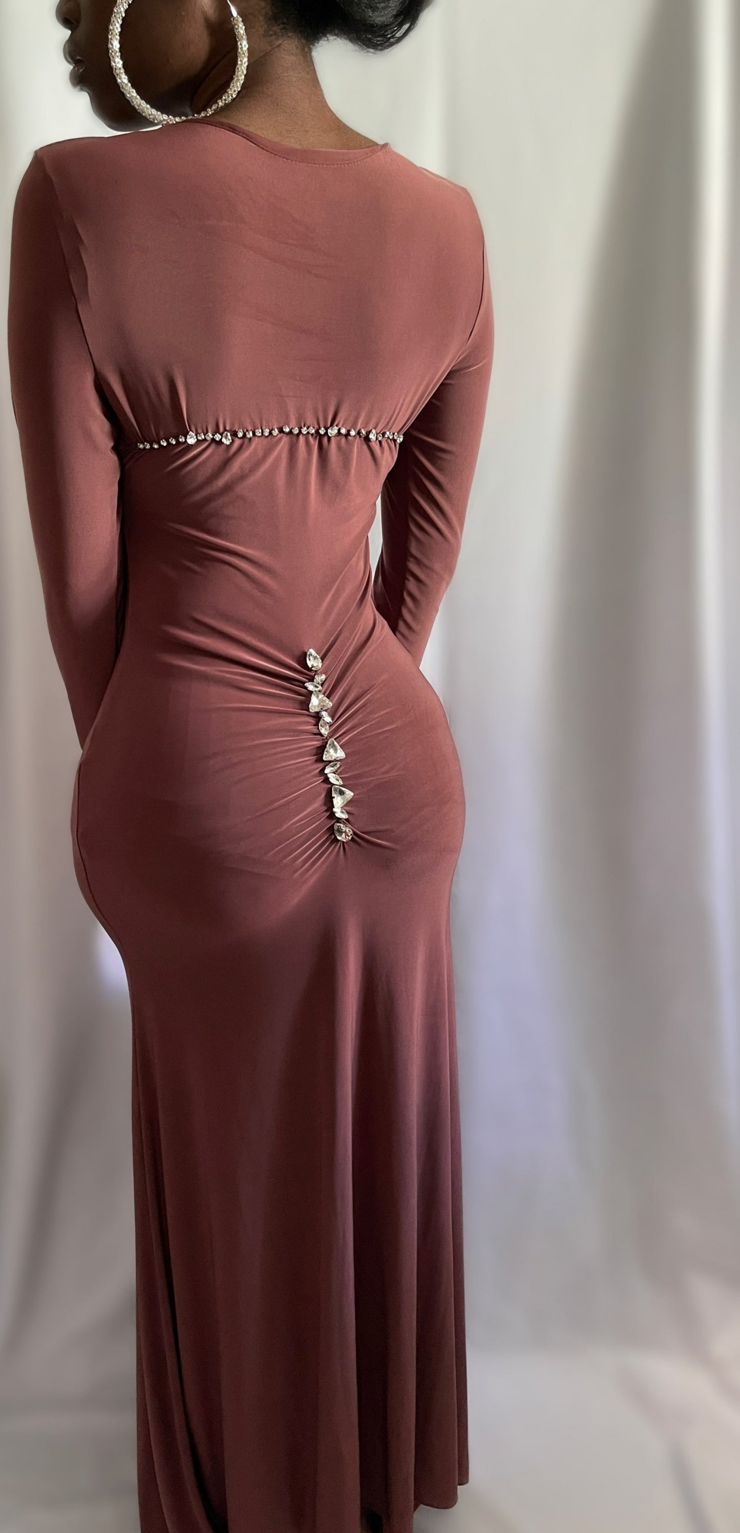 Back view of a mauve brown dress. The back of the dress features rhinestones down the center back and across shoulder width. 